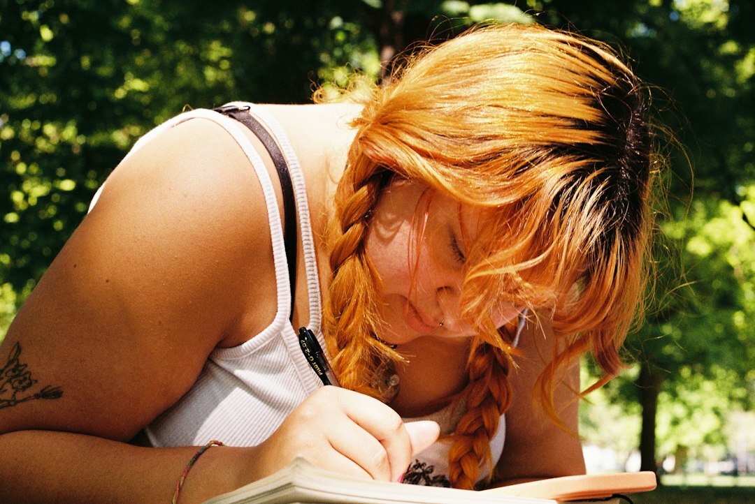 Mulher escrevendo em um caderno de desenvolvimento pessoal